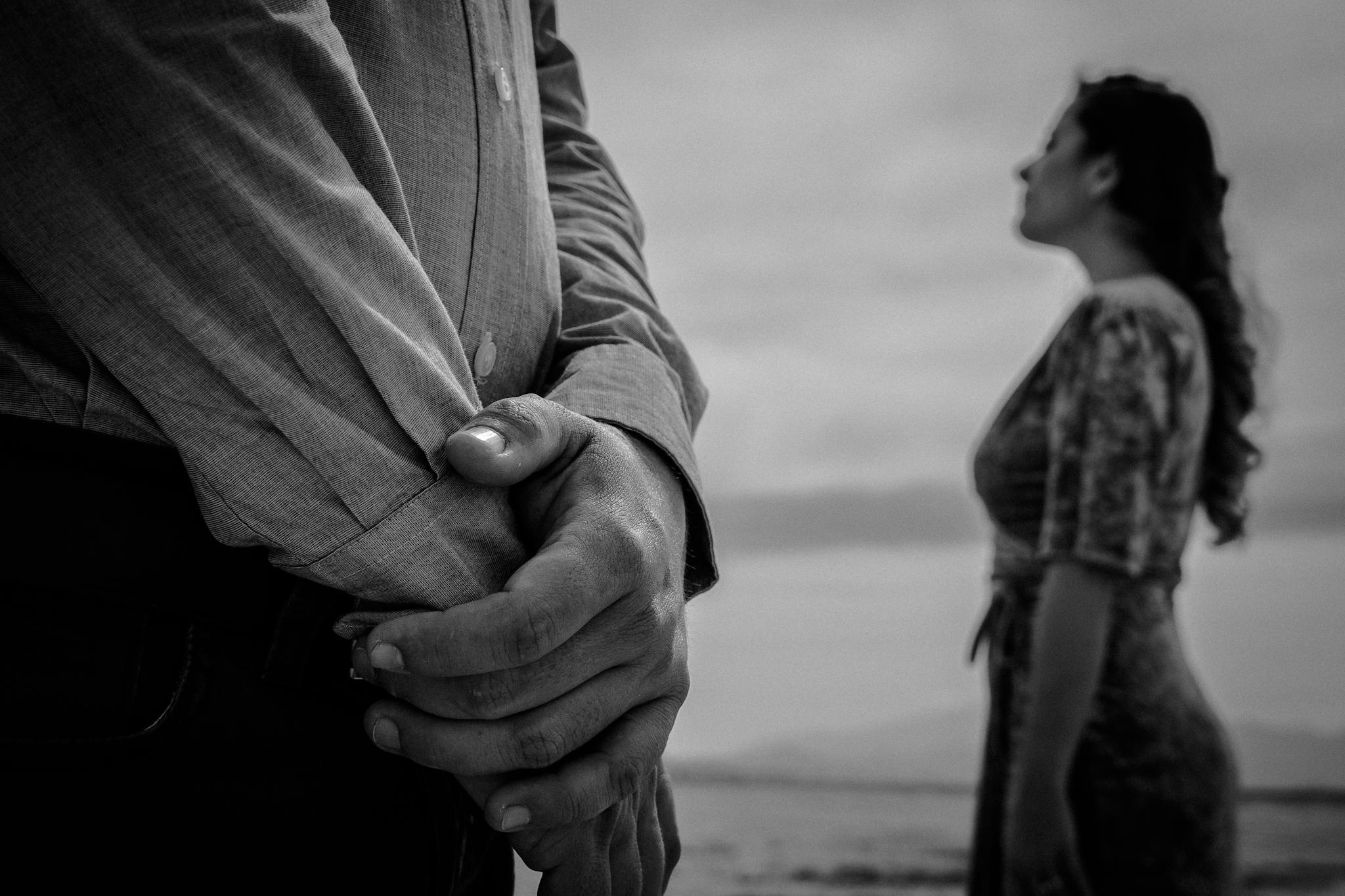 Artistic black and white portrait capturing a dramatic relationship moment by the sea.